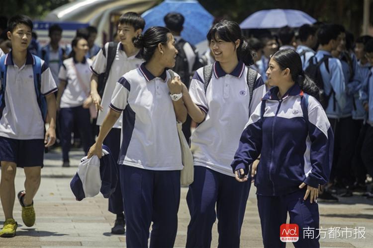 广州广铁一中番禺校区考点,走出考场的女学生手牵着手,边说边笑.