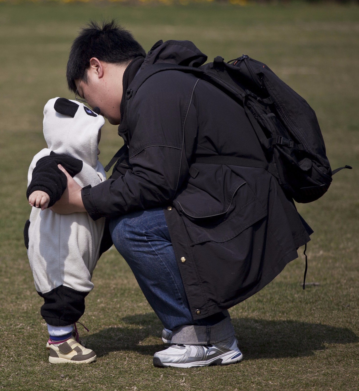 2011年3月2日,上海长宁区长宁路,一位父亲抱着穿着熊猫外套的孩子.