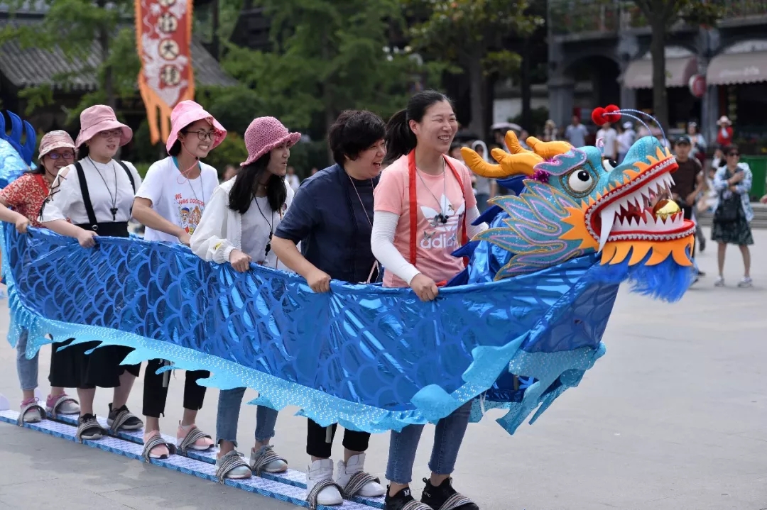 妙趣横生的旱地龙舟赛汇集了众多游客和当地市民,现场气氛活跃,划行时