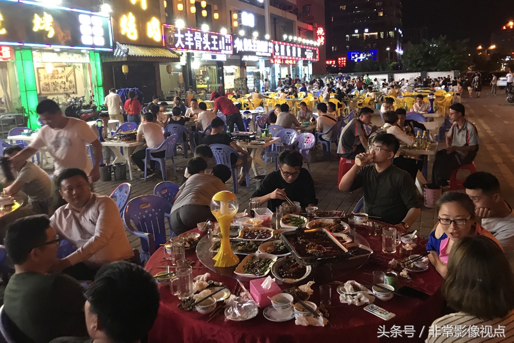 近千米长的美食街上,数千名市民围坐在桌前,边撸串喝啤酒边观看世界