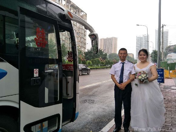 公交驾驶员程科和妻子站在车门前迎宾.