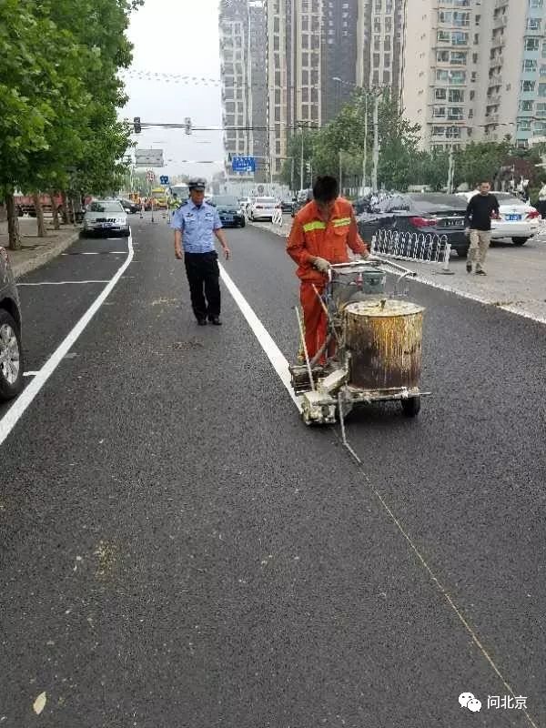 6月16号,小区西门外交警正在施划标线/张先生供