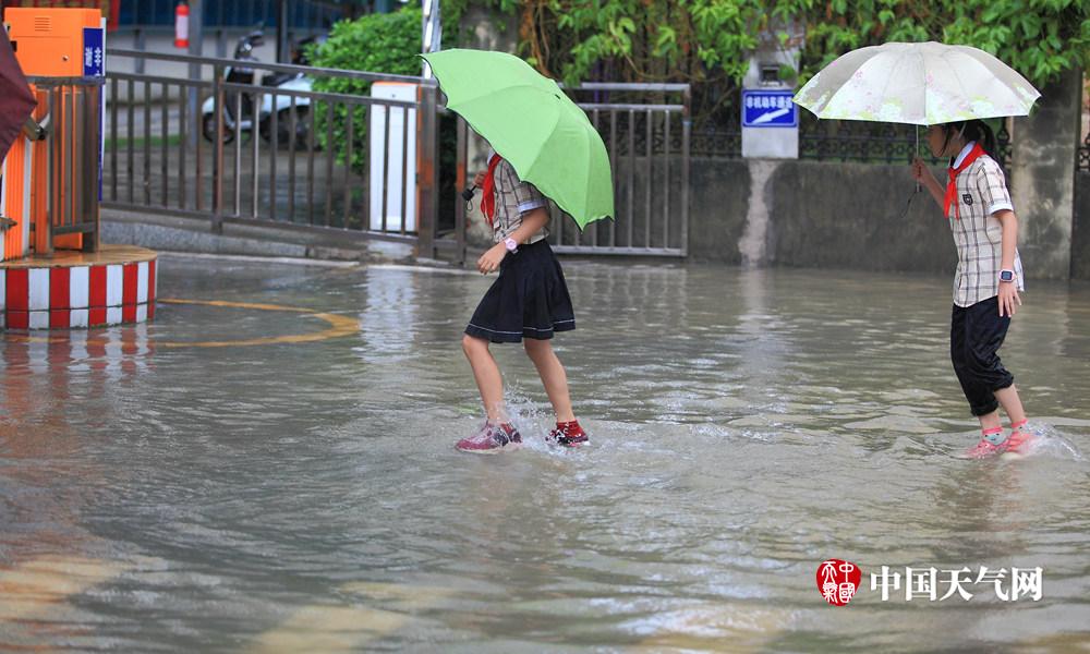 广西南宁大雨倾盆 城区内涝市民脱鞋趟水