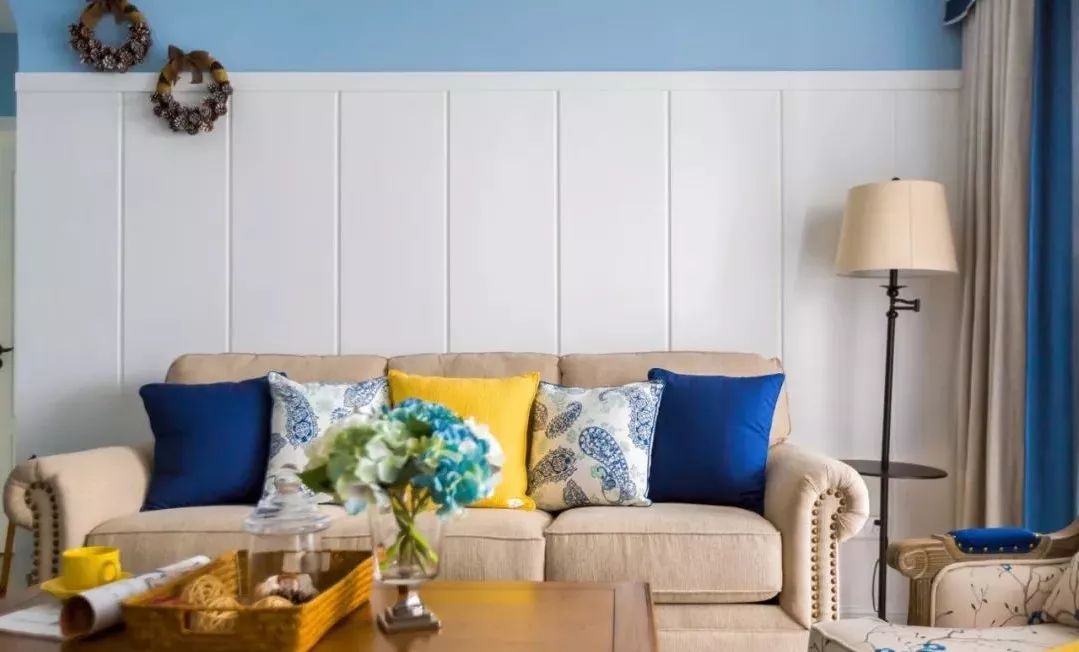沙发背景采用石膏板做护墙板,表面拉槽造型,搭配蓝色墙面,既节约了