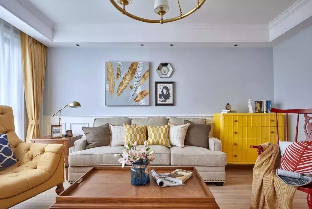 客厅地面通铺原木色地板,灰蓝色墙面搭配白色半高护墙,舒适的美式家具