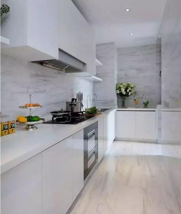 厨房间采用了白色调,放大了空间感,仿石材的瓷砖质感大气.