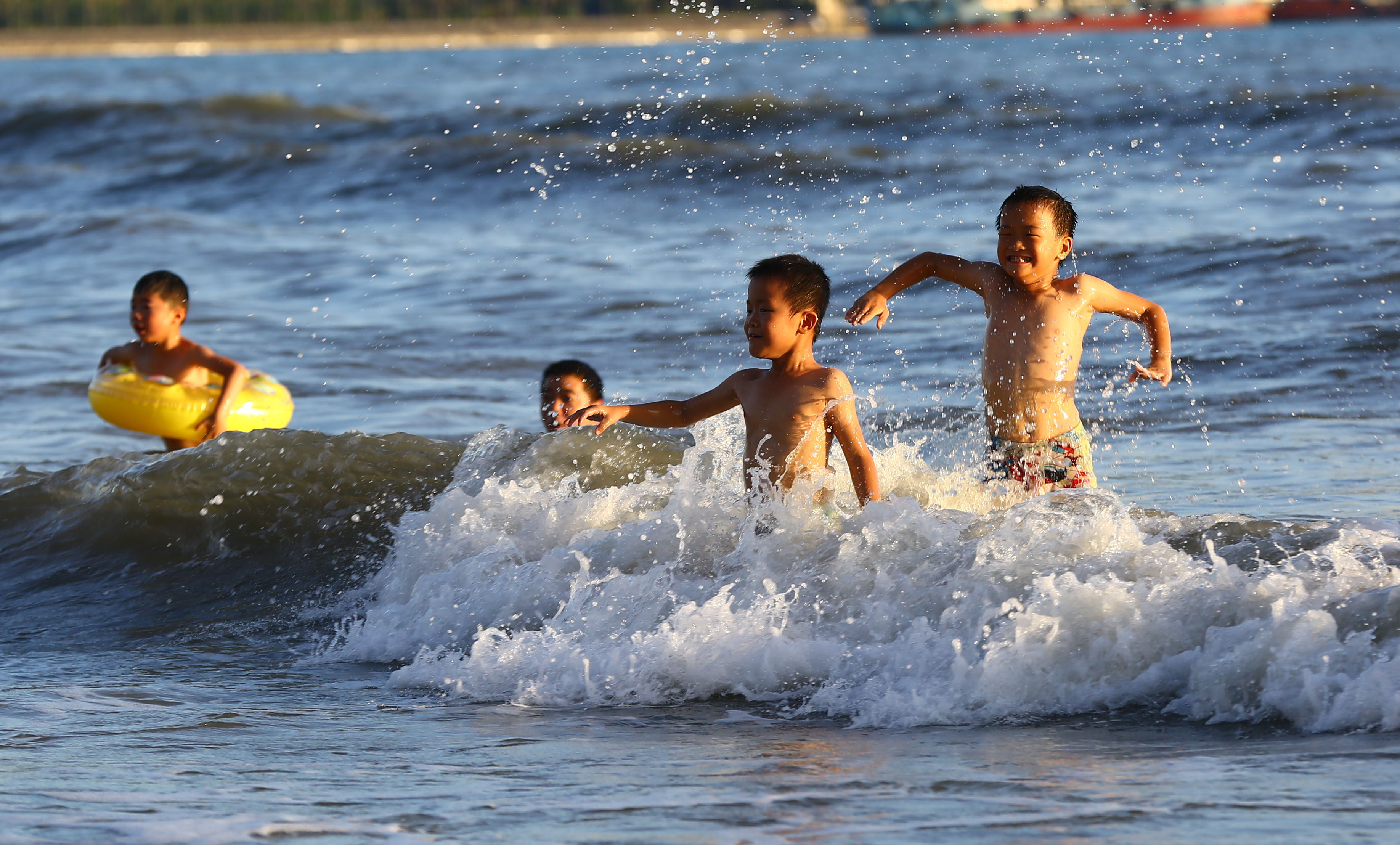 海南持续发布高温橙色预警,三亚市民纷纷来到海边戏水