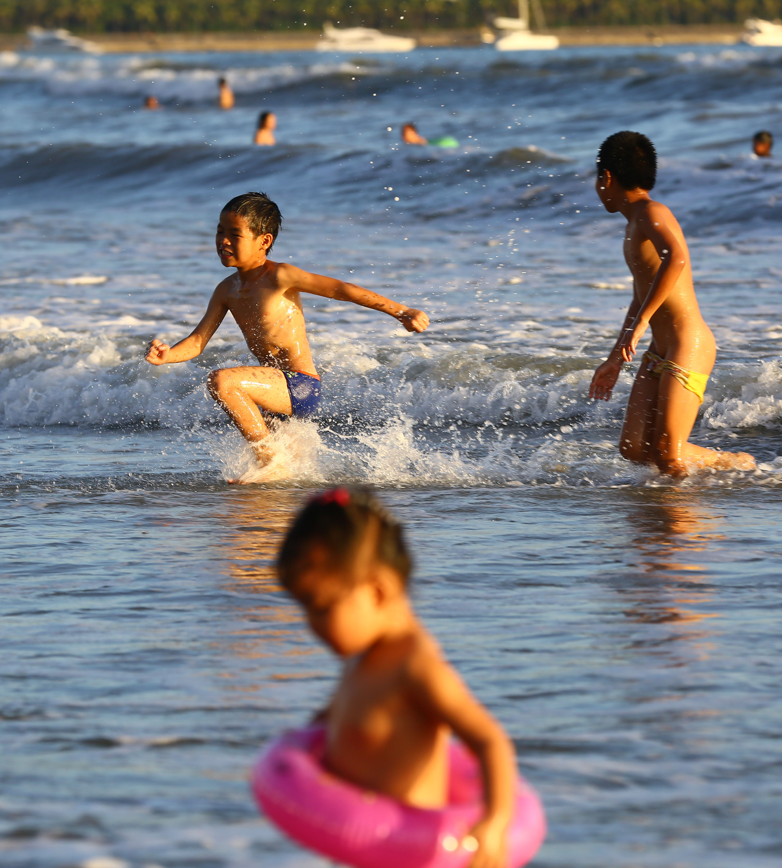 海南持续发布高温橙色预警,三亚市民纷纷来到海边戏水消暑