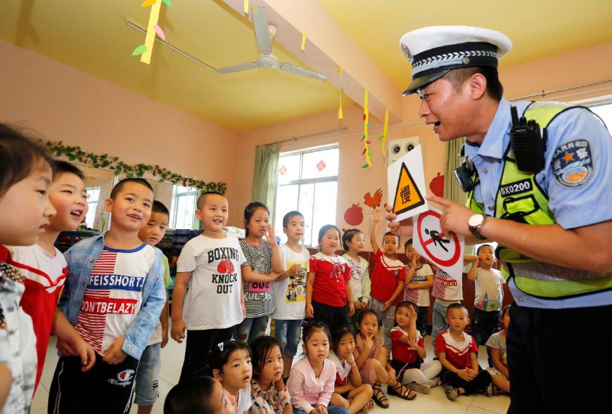 7月3日,高新区好妈妈幼儿园,民警向小朋友讲解暑期安全出行注意事项.