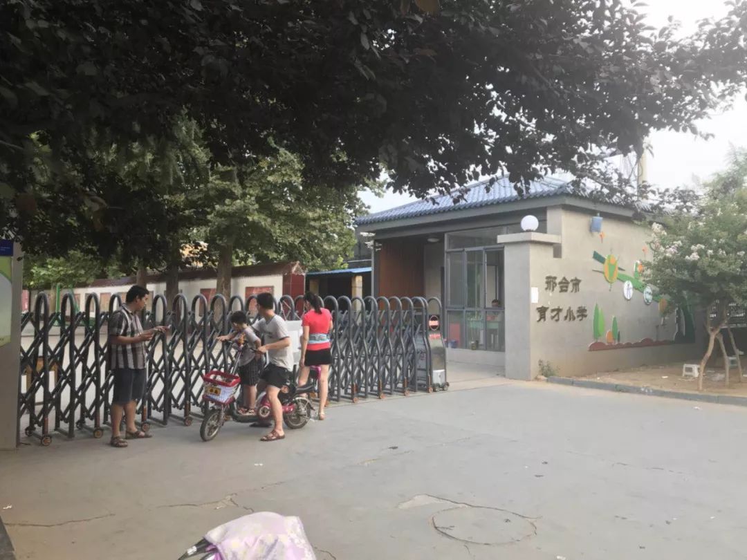 " 图为马路街小学校长在校门口为家