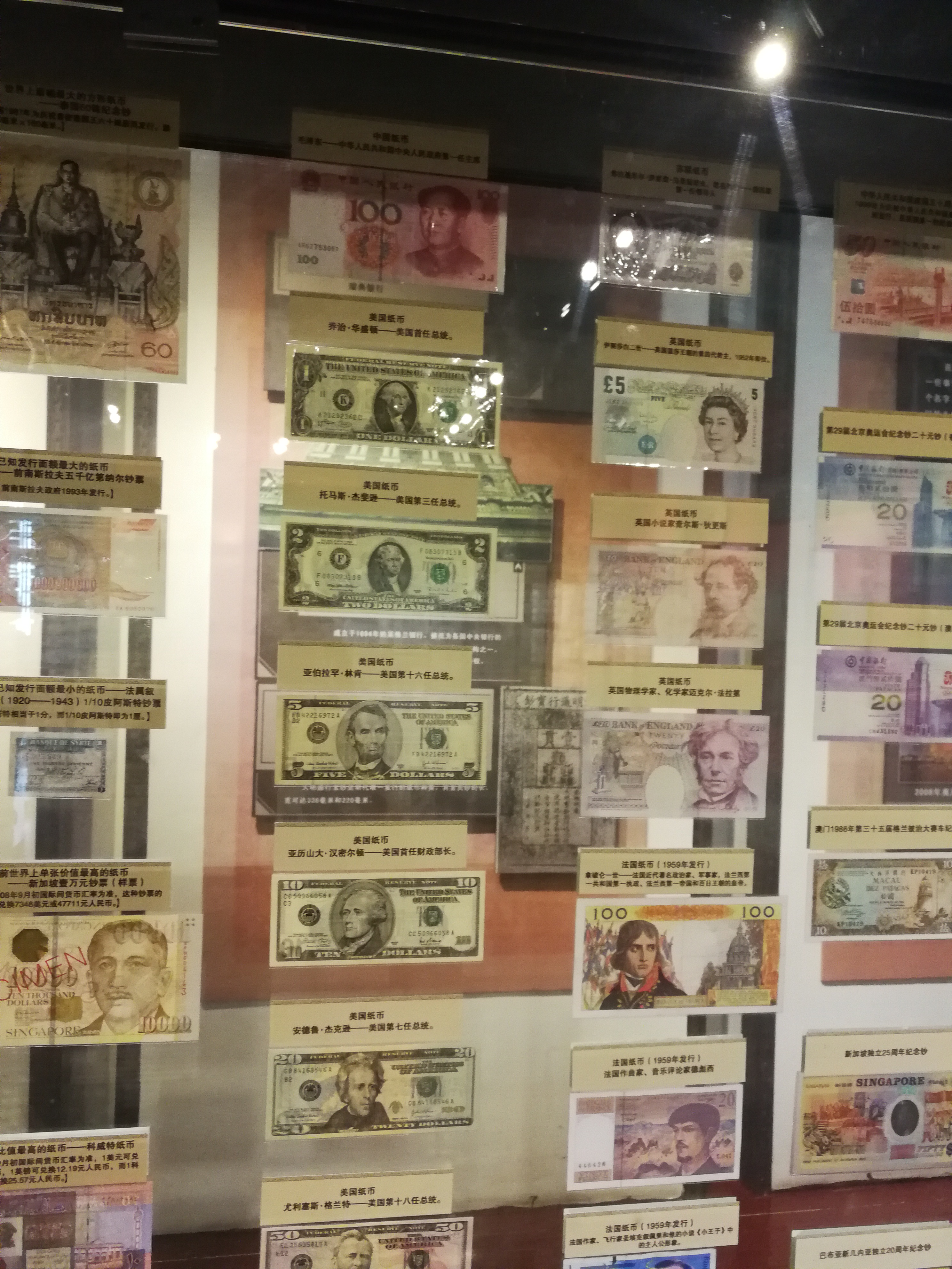 图为博物馆里的玻璃展示墙,表着世界各国不同时期的货币.