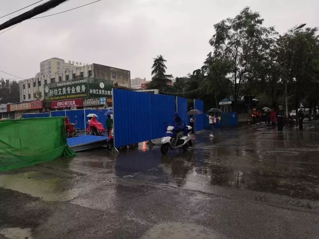 雨中执勤的交警 晋城文昌街与泽州路交叉口, 雨中封路后的新市街