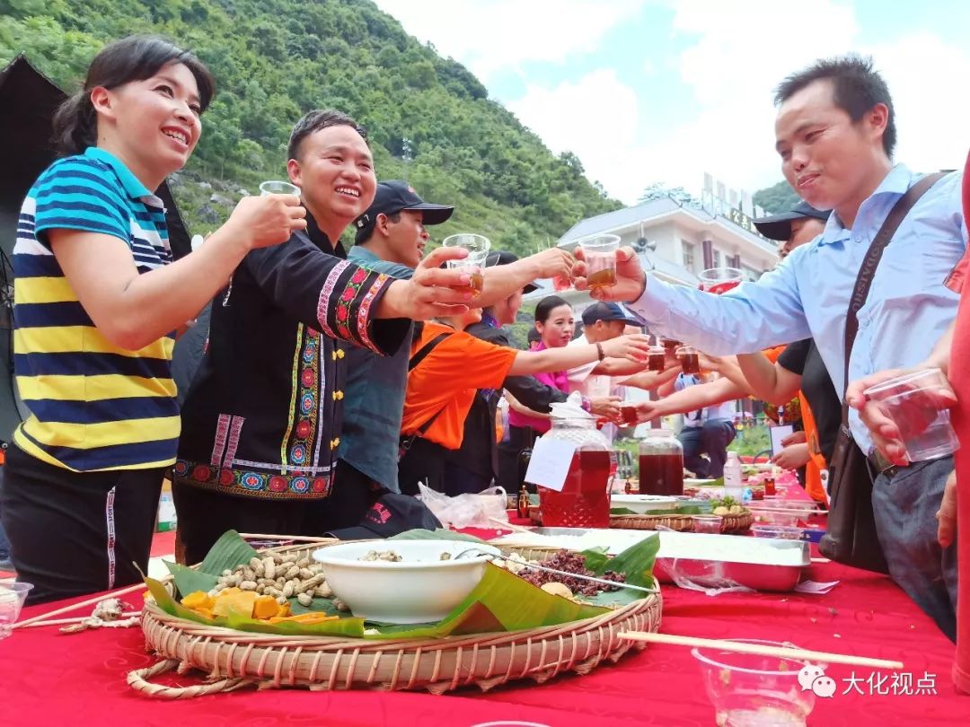 来宾品尝瑶家美食.唐毓春 摄县领导莫利细,周贵明,邓宝艳出席了活动.