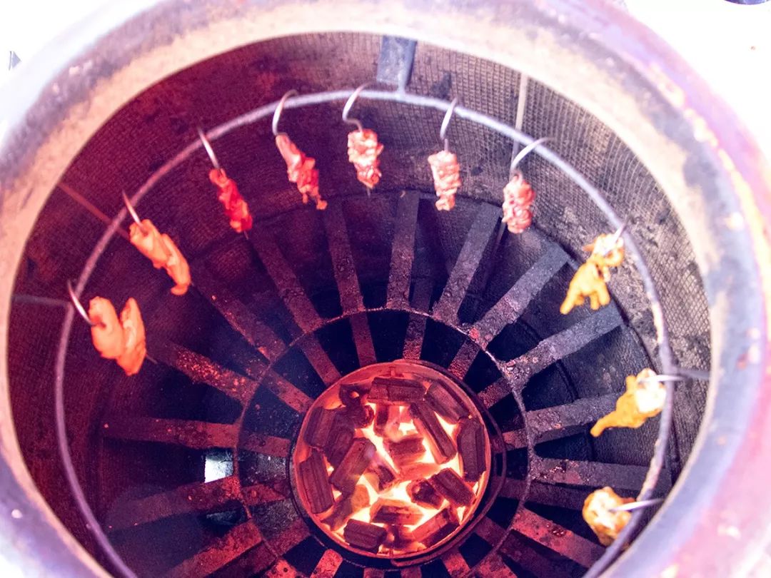 和传统烧烤的不同在于,吊炉能让肉串均匀的受热,封闭式的大圆缸,肉串