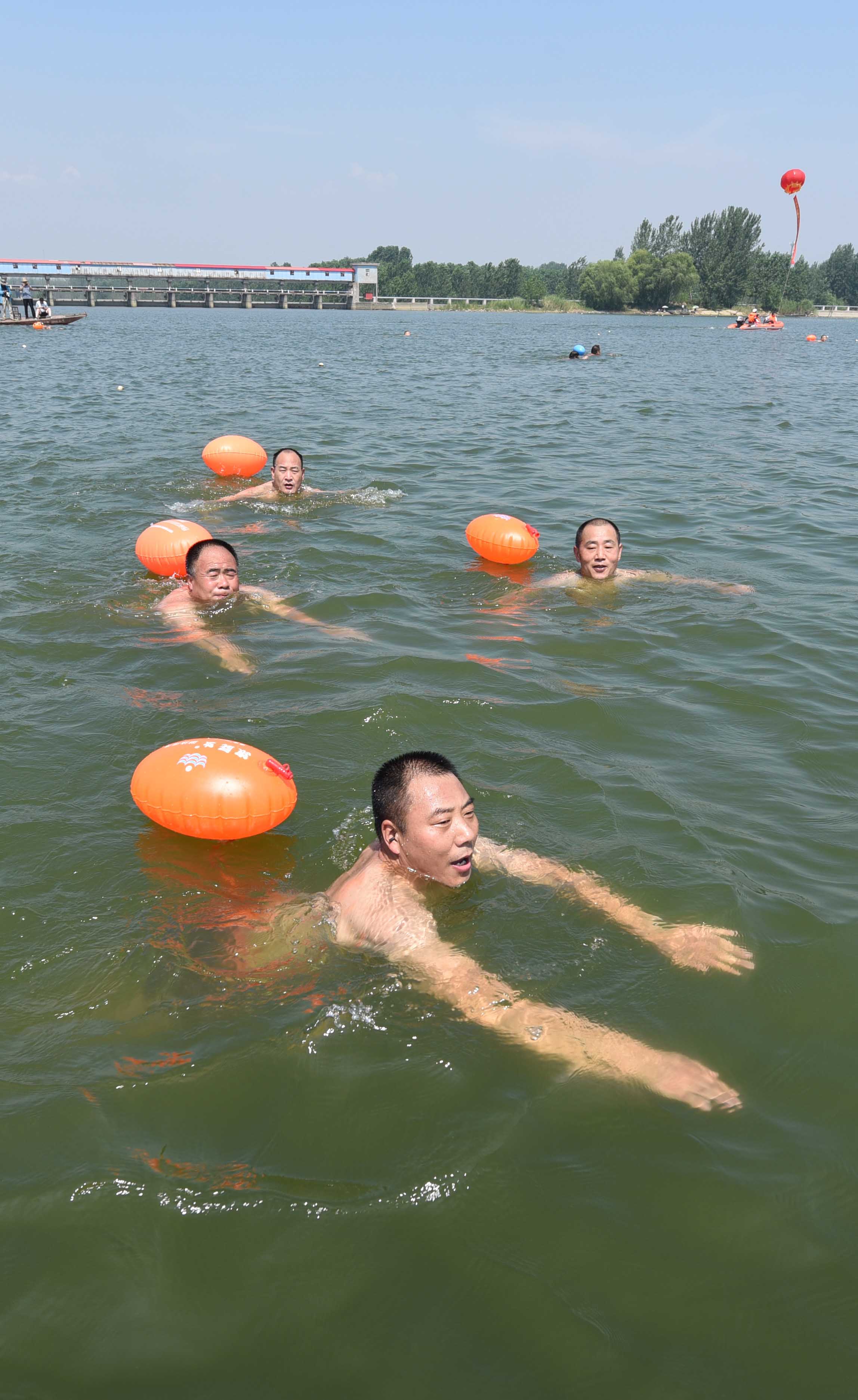 7月15日,游泳爱好者在山东省临沂市郯城县马头镇沂河水面参加畅游赛.