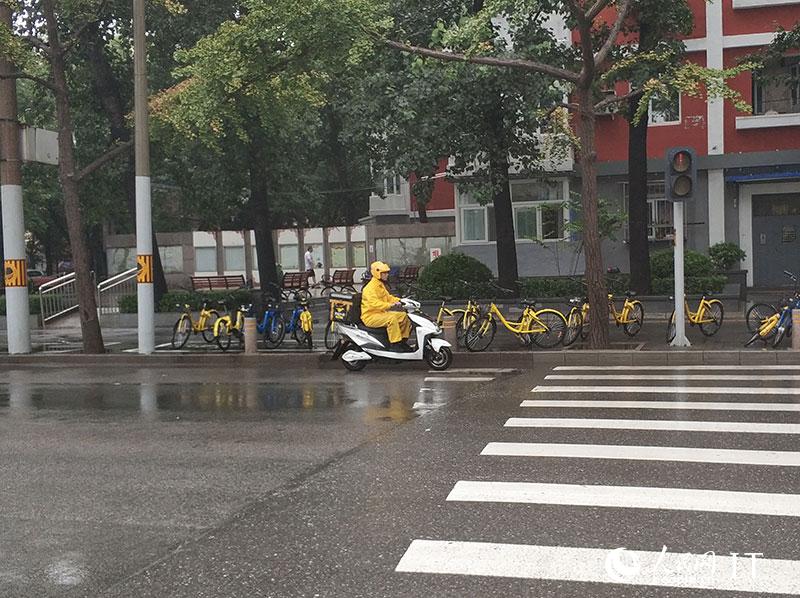 北京迎来强降雨快递小哥开启雨中送货模式