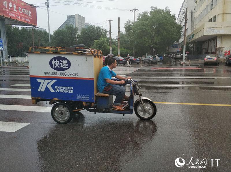 北京迎来强降雨快递小哥开启雨中送货模式