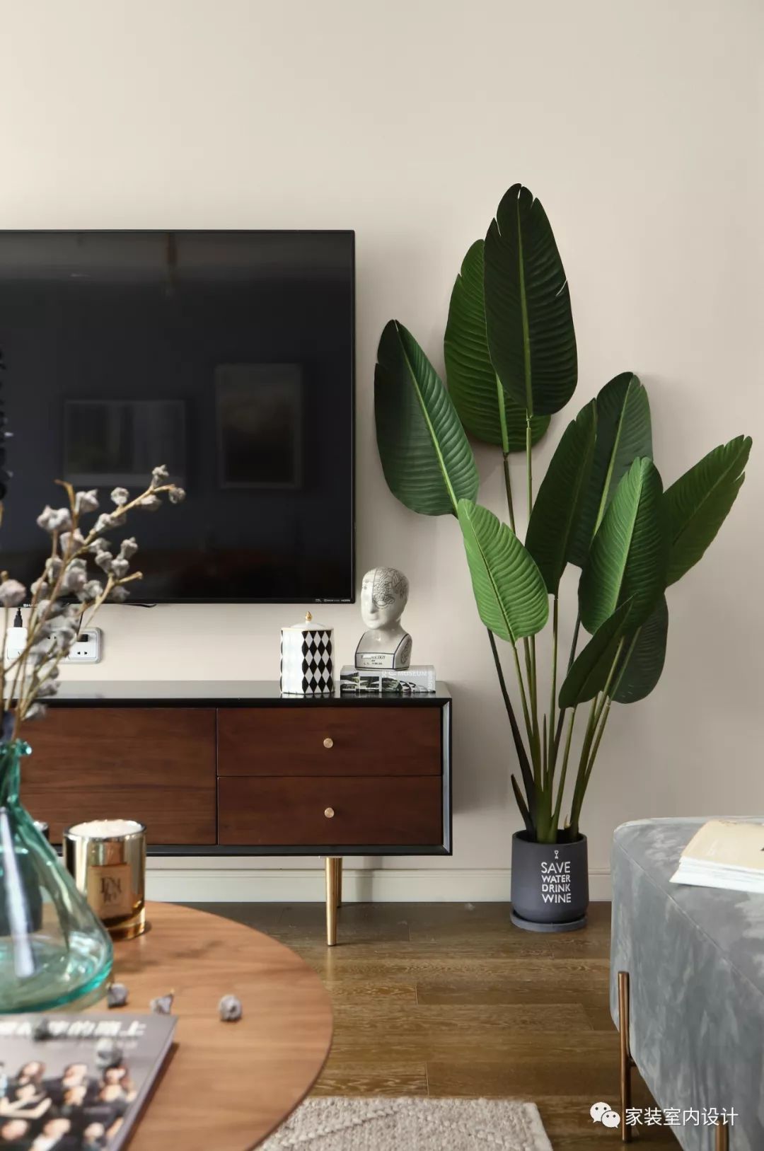 电视墙仅以木质电视柜与旁边的绿植做为装饰摆设,自然简约,给人一种