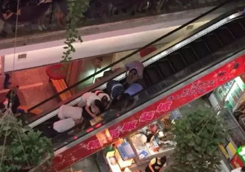 荆州沙市安良百货内,一女子带着儿子搭乘商场内手扶电梯上楼时,遭遇