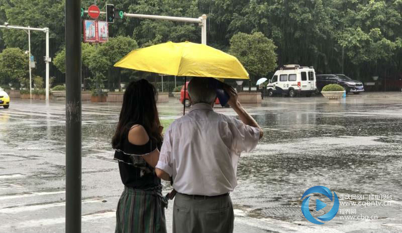 暴雨中的温情一幕 女子为陌生老人撑伞