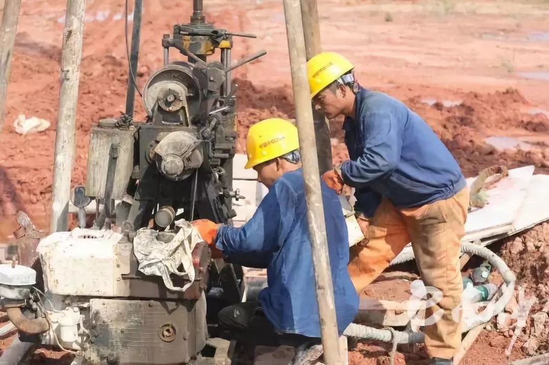 两位建筑工人正在修理他们的钻地机器