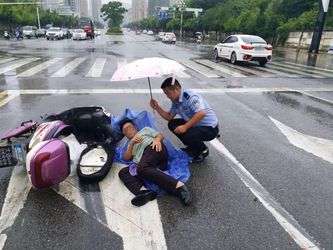 兴义交警雨中撑伞30多分钟,只因老大爷骑车雨中受伤!