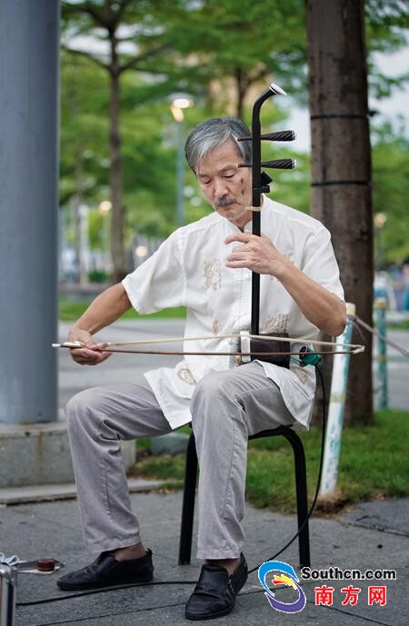 街头艺人骆宏俊,今年63岁,已在深圳拉二胡18年.