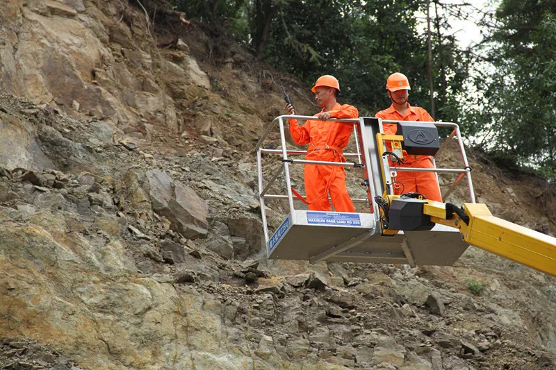 车快速过桥,到达山脚下,两名专家登上登高车,近距离勘查塌方山体情况