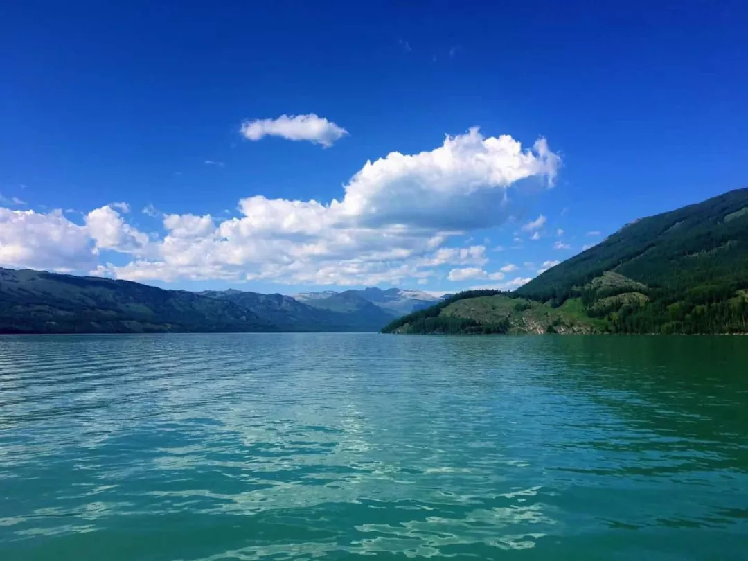 湖水碧绿,群山围绕,山林覆盖.