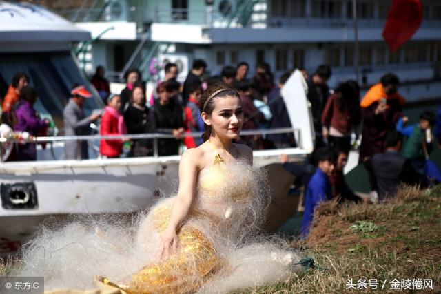 两名女大学生环保志愿者化身"美人鱼",在丹江库区一侧钻进渔网,由渔民