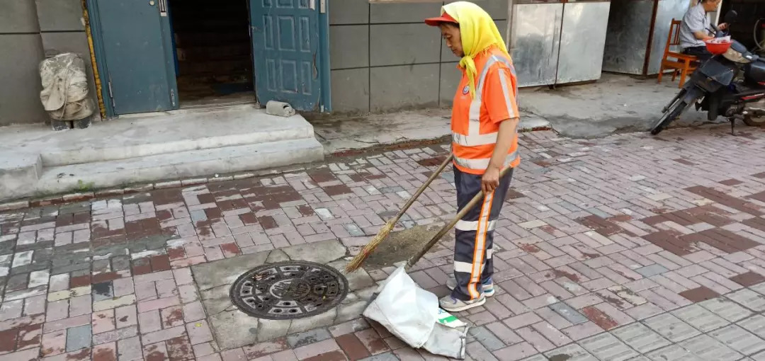 张殿芳正在打扫街道 图片来源:吉林文明网