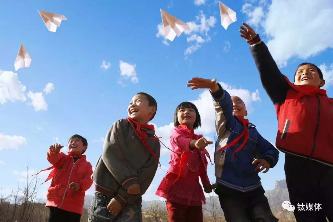 几个来自乡村小学的孩子放飞纸飞机./ 视觉中国