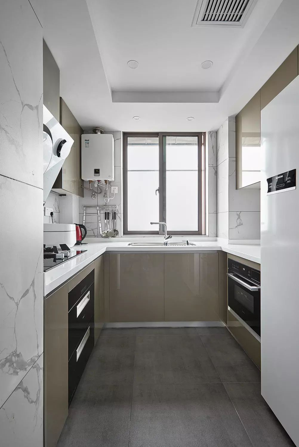 厨房采用棕色的柜门颜色,搭配白色纹理的瓷砖,带来清爽洁净的视觉感受
