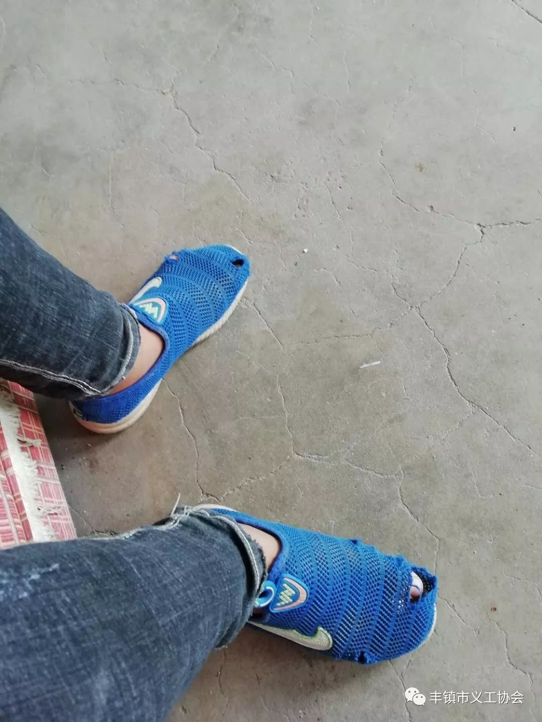 一位男学生鞋太破了,杨化工心疼不已,给他买了一双旅游鞋和一双袜子.