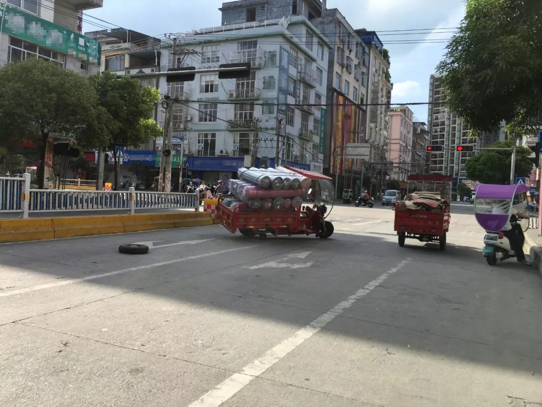 在宾阳美食街路口处, 拍到一部载满布料的三轮车横在红绿灯处无法