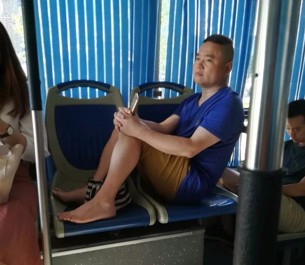 9月1日,从昆明飞往北京的航班上,一名中年男子脱掉鞋子,光着脚不断