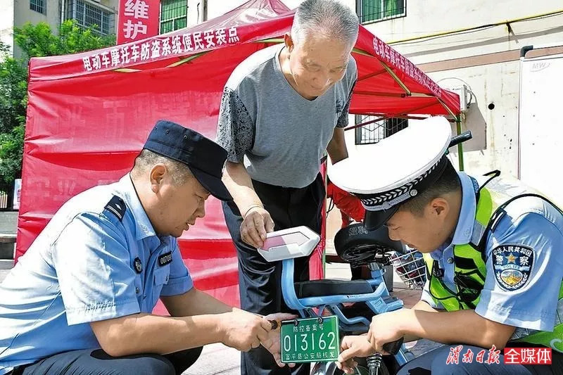 8月24日,民警在为群众电动车安装防盗车牌.