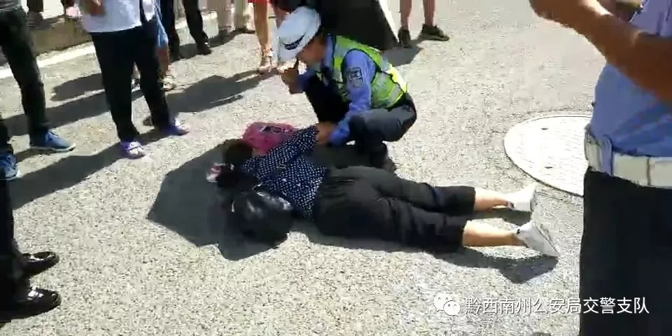 贞丰妇女受伤倒地!美女交警为其撑伞遮挡烈日