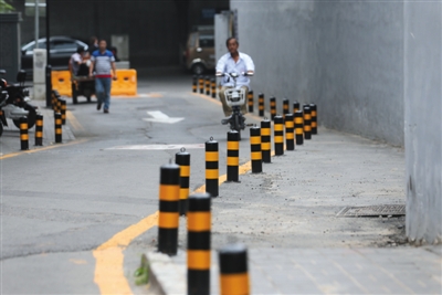 昨日,北官场胡同整治完成,道路两边设置阻车桩,实现不停车.