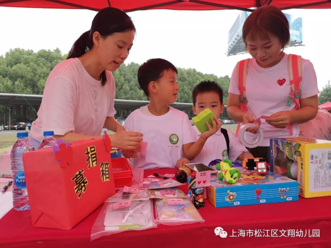 地拿起义卖物品走出摊位向居民们兜售,家长们更是乐此不疲地辅助收款