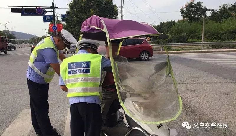 交警在全市各条道路上开展电动车拆除遮阳伞整治行动时,对违规安装的