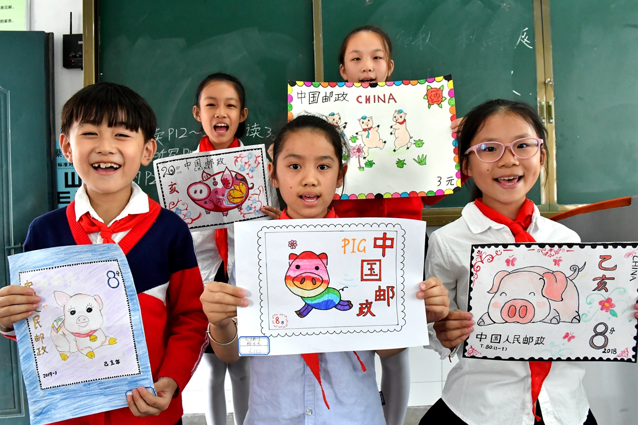 安徽省合肥市临泉路第二小学的学生们在设计猪年生肖邮票,了解邮票