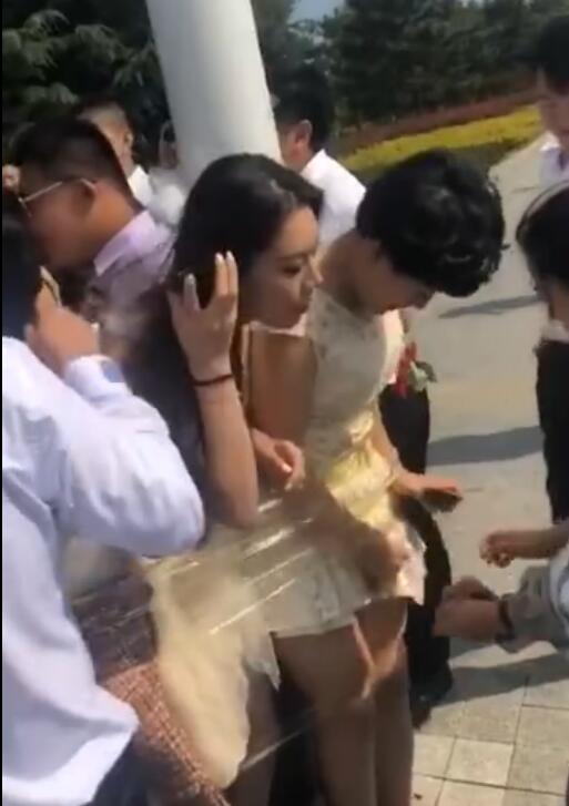 又见婚闹?伴娘与新郎被绑路灯杆下 众人哄笑拍照