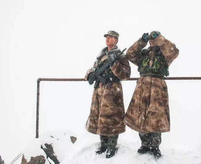 哨所战士正在雪中系着背包绳站岗.