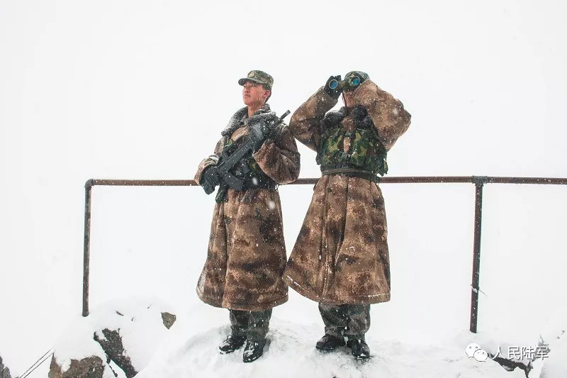 哨所战士正在雪中系着背包绳站岗. 牌杰 摄