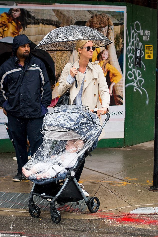 名媛帕丽斯希尔顿的妹妹妮基希尔顿拿着伞女儿在雨中的曼哈顿散