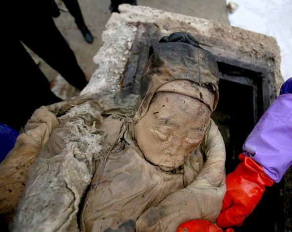 照片七,考古人员正在清理尸体上包裹的衣物