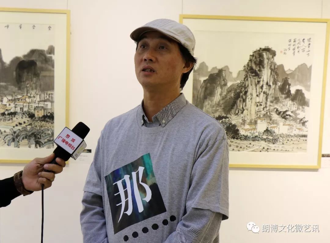 那山那水画社社长喻湘龙接受罗城电视台的采访现场观众观看精美的展览