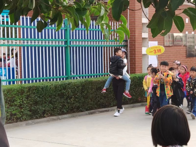 10月18日,郑州市惠济区实验小学出现了"女教师抱着学生放学"的一幕.