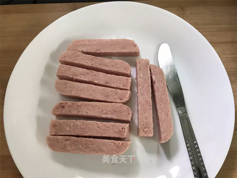 午餐肉从罐头中取出后切成大小合适的长条状.3.